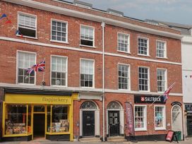 A storefront with flags and signage at FLAT 1 53a Broad Street (1 Bedroom Sleeping 2) Lyme Regis
