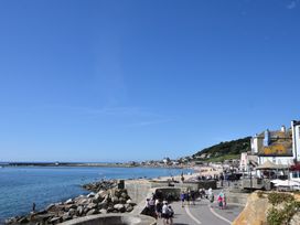 A beach scene with people and buildings at FLAT 1 53a Broad Street (1 Bedroom Sleeping 2) Lyme Regis