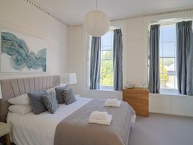 A bedroom with a bed and windows at The Tides in Lyme Regis