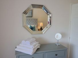 A bedroom with a mirror, towels, and a dresser at FLAT 2 53a Broad Street (1 Bedroom Sleeping2) Lyme Regis