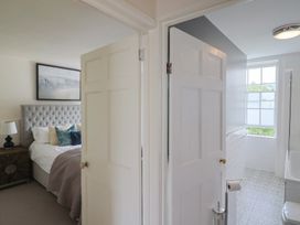 A bedroom with a bed and nightstand leading to a bathroom at FLAT 2 53a Broad Street (1 Bedroom Sleeping2) Lyme Regis
