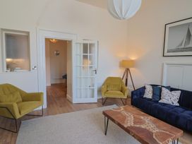 A living room with a sofa, chairs, and a coffee table at Saltwind in Lyme Regis