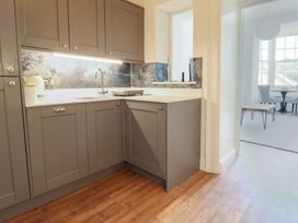 A kitchen with grey cabinets and a sink at Saltwind in Lyme Regis