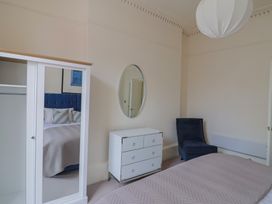 A bedroom with a wardrobe and a bed at Saltwind in Lyme Regis