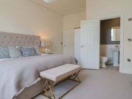 A bedroom with a bed and an en-suite bathroom at Saltwind in Lyme Regis