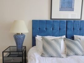 A bedroom with a blue headboard and lamp at Saltwind in Lyme Regis