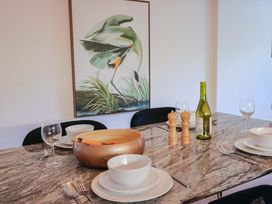 A dining table set with plates and a wine bottle at Pebble Cove in Lyme Regis