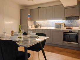 A kitchen with a table set for dining at Pebble Cove in Lyme Regis