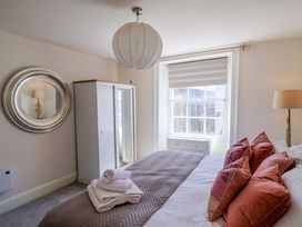A bedroom with a bed and wardrobe at Pebble Cove in Lyme Regis