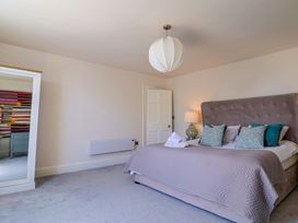 A bedroom with a bed and a mirror at Pebble Cove in Lyme Regis