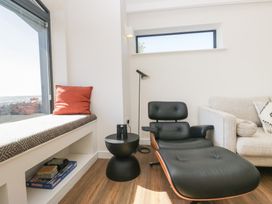 A living room with a chair and side table at Driftwood Cottage in Ulverston
