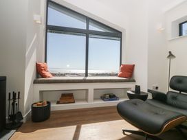 A living room with a window seat and chair at Driftwood Cottage in Ulverston