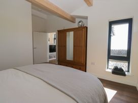 A bedroom with a bed and wardrobe at Driftwood Cottage in Ulverston