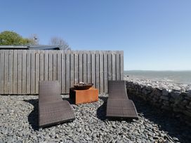 An outdoor space with deck chairs and a fire pit at Driftwood Cottage Ulverston
