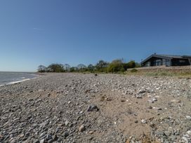 A beach with rocks and a house at Driftwood Cottage in Ulverston