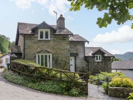 A house with a garden and pathway at Hollens Cottage in Grasmere