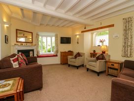 A living room with seating and a television at Hollens Cottage in Grasmere
