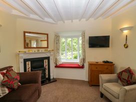 A living room with a fireplace and window seat at Hollens Cottage Grasmere