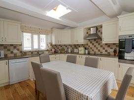 A kitchen with cabinets and a dining table at Hollens Cottage in Grasmere