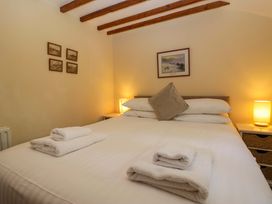 A bedroom with a bed and lamps at Hollens Cottage in Grasmere