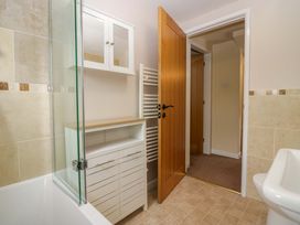 A bathroom with a bathtub and shower at Hollens Cottage in Grasmere