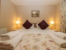 A bedroom with a bed and bedside tables at Hollens Cottage in Grasmere