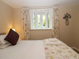 A bedroom with a bed and window at Hollens Cottage in Grasmere