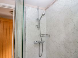 A shower with a chrome showerhead and control in a bathroom at Hollens Cottage Grasmere