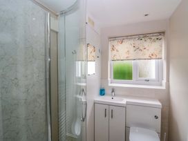 A bathroom with a shower and sink at Hollens Cottage Grasmere