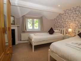 A bedroom with two beds and a window at Hollens Cottage in Grasmere