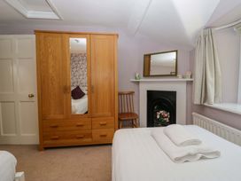 A bedroom with a wardrobe and a chair at Hollens Cottage in Grasmere