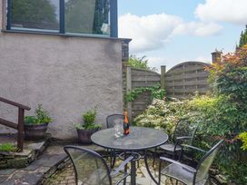 A garden with a table and chairs at Hollens Cottage in Grasmere