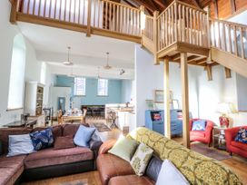 A living room with a sofa and dining area at Church Llygad Y Dyffryn in Sarnau near Brynhoffnant