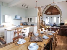 A kitchen and dining area with a table set for dinner at Church Llygad Y Dyffryn in Sarnau near Brynhoffnant