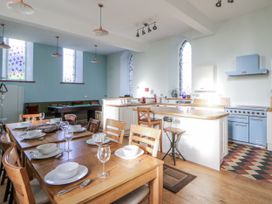 A kitchen with a dining area and stained glass windows at Church Llygad Y Dyffryn in Sarnau near Brynhoffnant