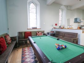 A recreation room with a pool table and benches at Church Llygad Y Dyffryn Sarnau near Brynhoffnant