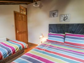 A bedroom with two beds and a door at Church Llygad Y Dyffryn Sarnau near Brynhoffnant