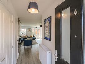A hallway with a door and a view into a living area at Inishnee House in Shotley Gate