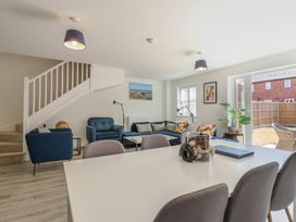 A living room with a sofa, armchair, coffee table and dining area at Inishnee House in Shotley Gate