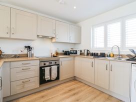 A kitchen with cabinets, sink, oven, microwave, and kettle at Inishnee House Shotley Gate
