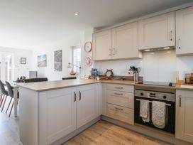 A kitchen with cabinets, oven, and seating area at Inishnee House in Shotley Gate