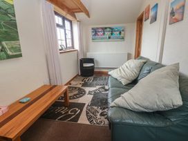 A snug area with a sofa and coffee table at Horseshoe Cottage Near Holywell Bay
