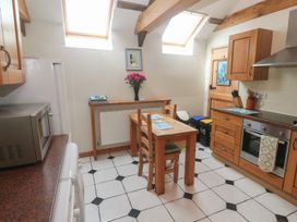 A kitchen with a table and chairs at Horseshoe Cottage Near Holywell Bay