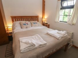 A bedroom with a bed and wardrobe at Horseshoe Cottage near Holywell Bay