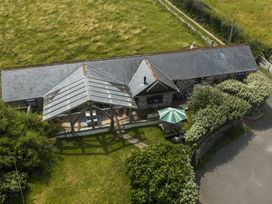 A patio with seating area and parasol at Horseshoe Cottage near Holywell Bay