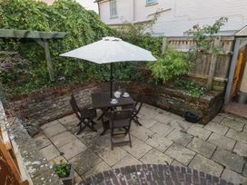 A garden with a table and chairs under an umbrella at Miller's Cottage in Puddletown