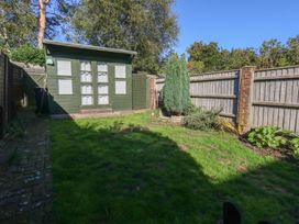 A garden with a shed and green grass at Miller's Cottage in Puddletown