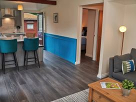 A kitchen with bar stools and a doorway at Ramson in Saltburn-By-The-Sea