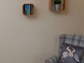 A living room with books on a shelf and a chair at Ramson in Saltburn-By-The-Sea