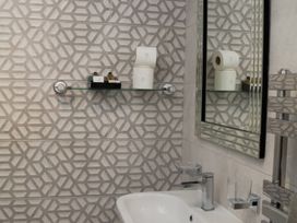 A bathroom featuring a bath tub and mirror at Ramson in Saltburn-By-The-Sea